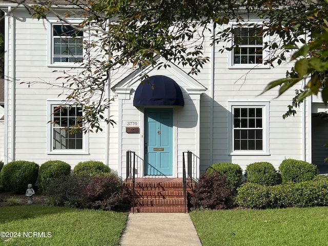 doorway to property with a yard