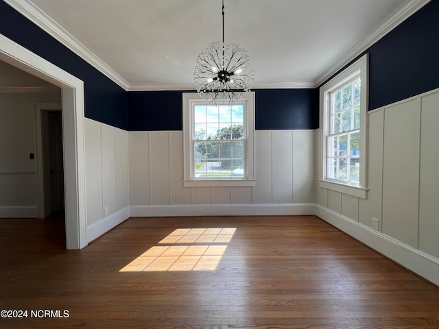 unfurnished dining area featuring ornamental molding, hardwood / wood-style floors, and a chandelier