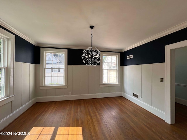 unfurnished dining area featuring a notable chandelier, crown molding, and dark wood-type flooring