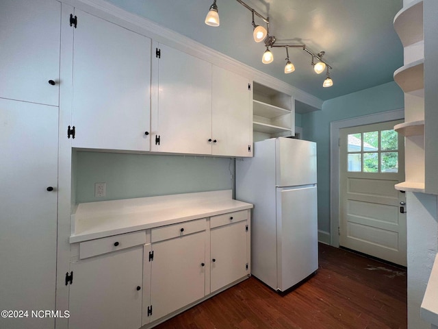 kitchen with white cabinets, white fridge, and dark hardwood / wood-style flooring