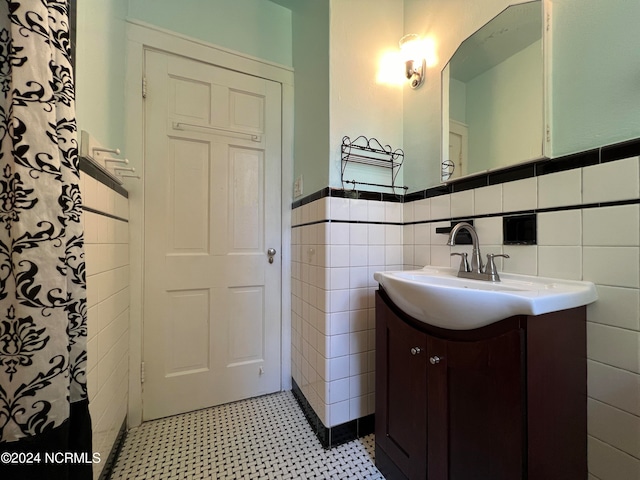 bathroom featuring vanity and tile walls