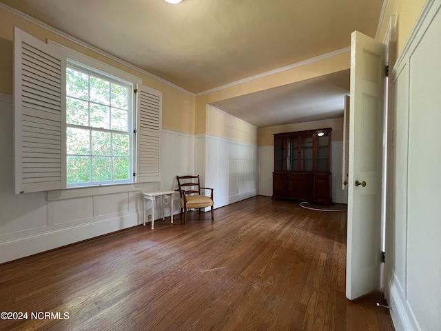 empty room featuring ornamental molding and dark hardwood / wood-style flooring