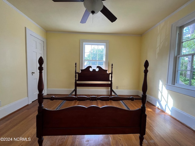 bedroom featuring ceiling fan, hardwood / wood-style flooring, and crown molding