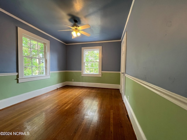 spare room featuring ceiling fan, plenty of natural light, ornamental molding, and dark hardwood / wood-style floors