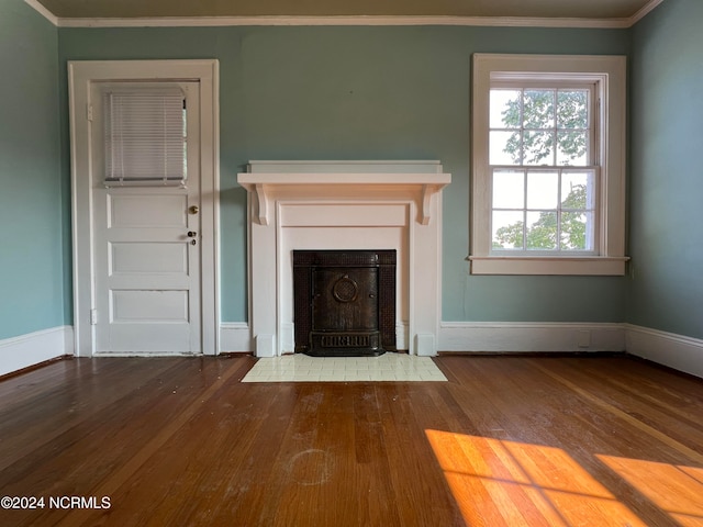 unfurnished living room featuring ornamental molding and hardwood / wood-style flooring