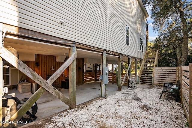 view of side of property featuring stairs, a patio, and fence