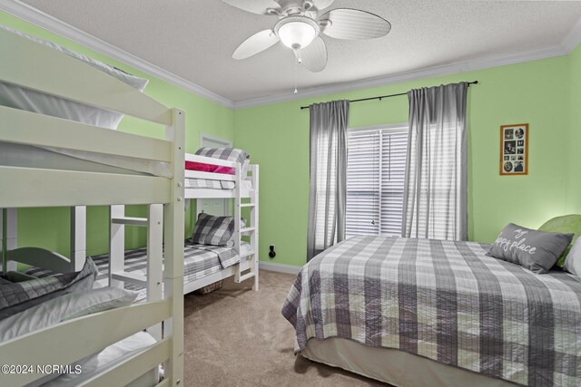 carpeted bedroom with ceiling fan, a textured ceiling, and ornamental molding