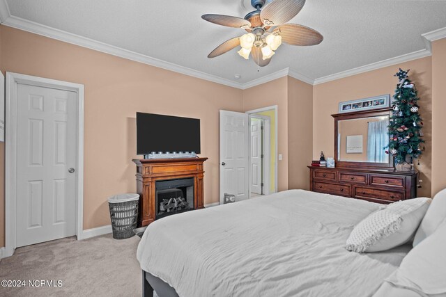 carpeted bedroom with ceiling fan, crown molding, and a textured ceiling