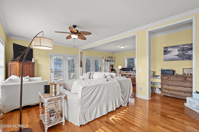 bedroom with a ceiling fan, crown molding, a textured ceiling, and wood finished floors