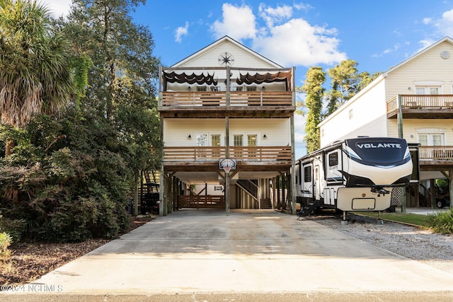 view of front of property with a balcony, a carport, and concrete driveway