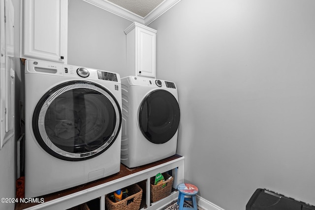 laundry area featuring washer and clothes dryer, cabinet space, ornamental molding, a textured ceiling, and baseboards