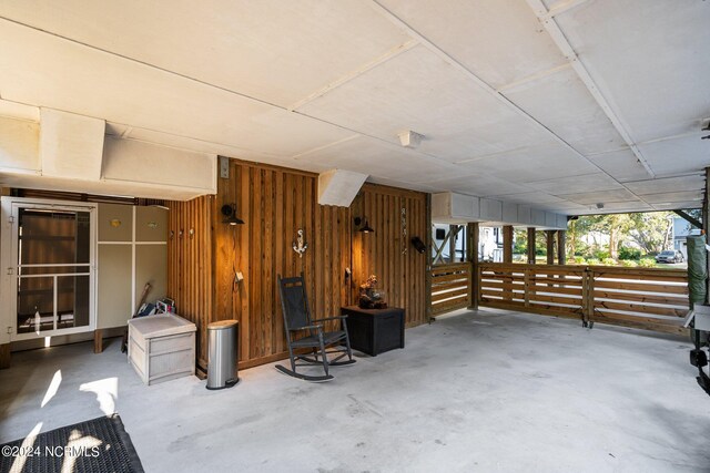 miscellaneous room featuring concrete floors and wooden walls