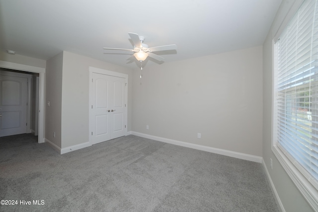 unfurnished bedroom with carpet, a closet, and baseboards