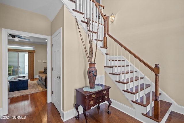 stairs with lofted ceiling, ceiling fan, and hardwood / wood-style floors