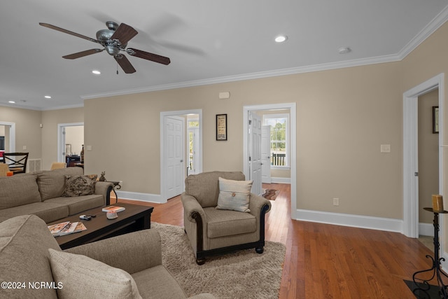 living room featuring crown molding, wood finished floors, and baseboards