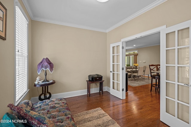 sitting room with wood finished floors, baseboards, french doors, plenty of natural light, and crown molding