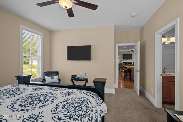 carpeted bedroom featuring ceiling fan, sink, and connected bathroom