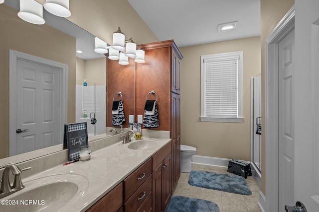 full bathroom with double vanity, a sink, toilet, and baseboards