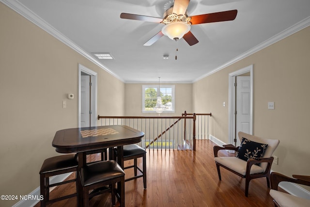 interior space with wood finished floors, visible vents, an upstairs landing, baseboards, and ornamental molding