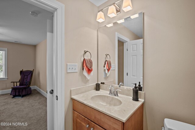 bathroom featuring baseboards, vanity, and toilet