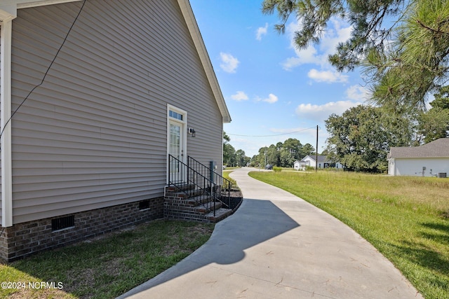 view of home's exterior with crawl space and a yard