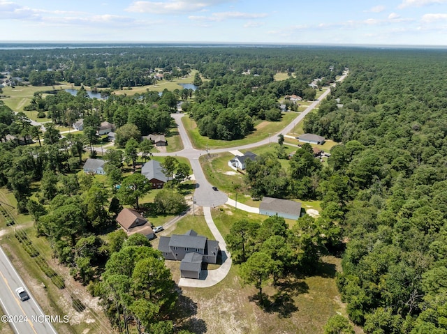 birds eye view of property with a forest view and a water view