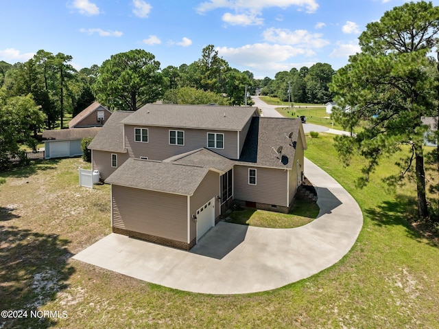 view of front of property featuring an attached garage, driveway, a front lawn, and roof with shingles