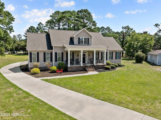 cape cod-style house featuring a front lawn and covered porch