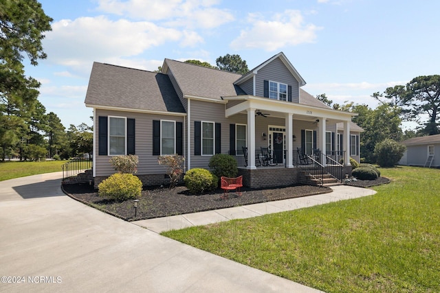 view of front of home featuring ceiling fan, a porch, a front lawn, and a shingled roof