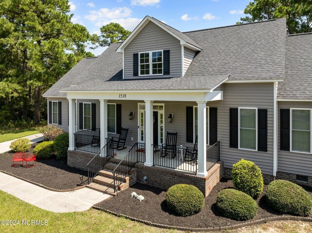 new england style home featuring a porch