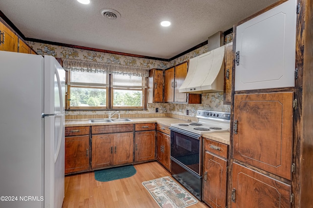 kitchen featuring sink, white appliances, a textured ceiling, light hardwood / wood-style flooring, and ventilation hood