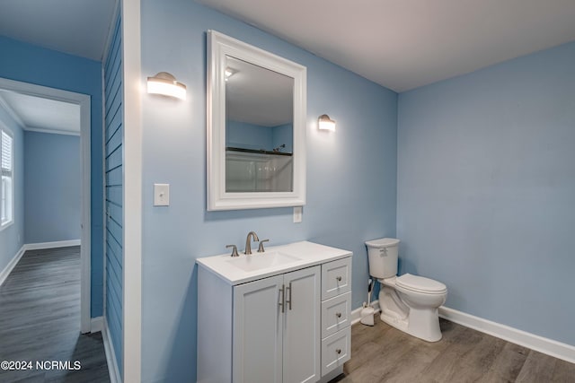 bathroom featuring a shower, hardwood / wood-style flooring, vanity, and toilet