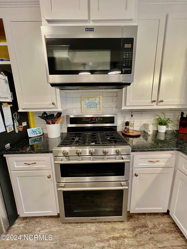 kitchen featuring stainless steel appliances, white cabinetry, and decorative backsplash