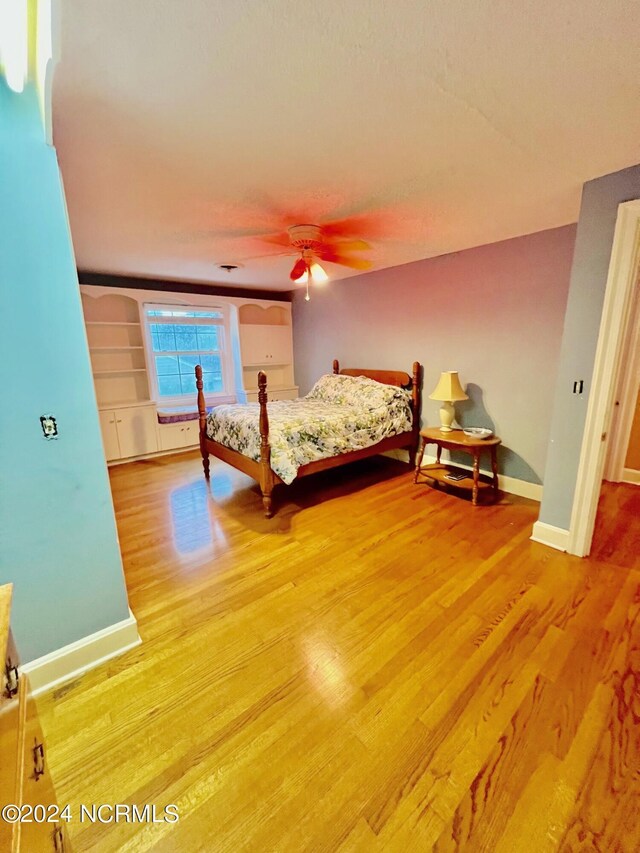 unfurnished bedroom with a ceiling fan, baseboards, and wood finished floors