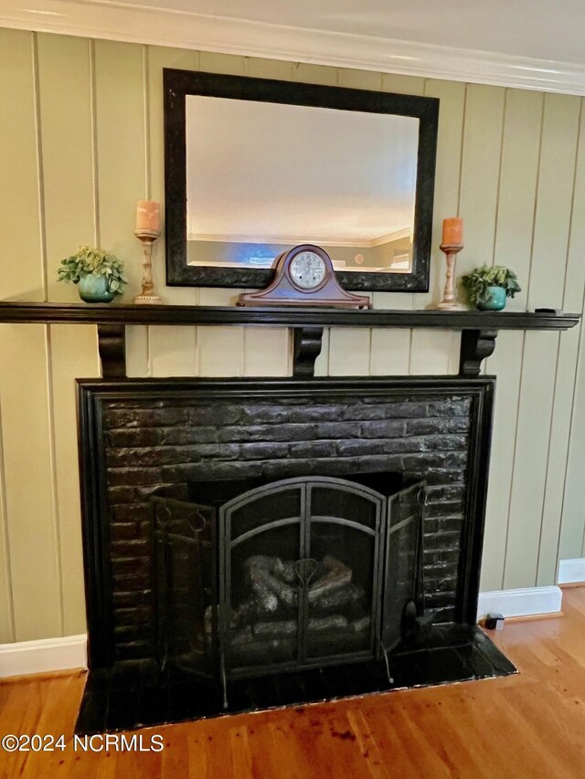 interior details with a fireplace, a decorative wall, and wood finished floors