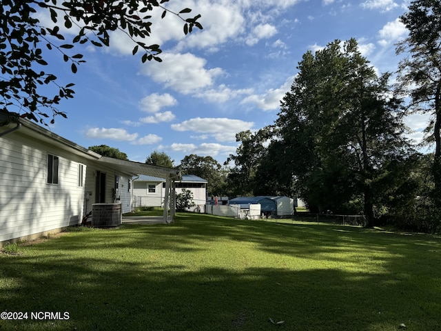 view of yard with fence and central air condition unit