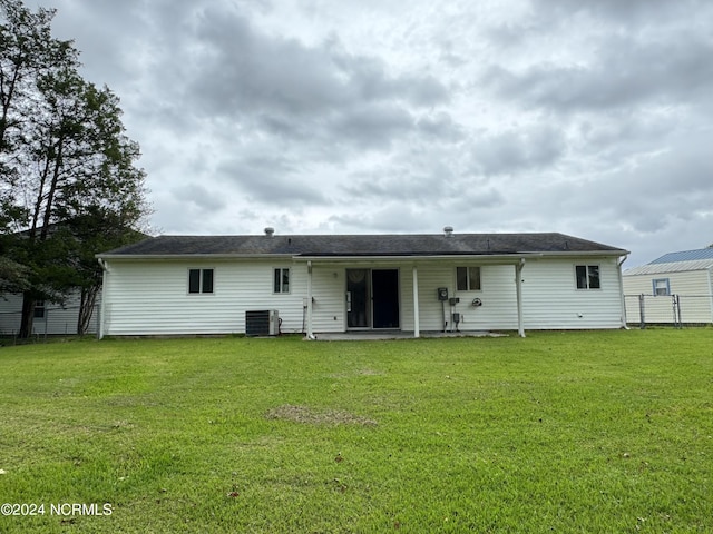 back of house featuring a yard, central AC, and a patio