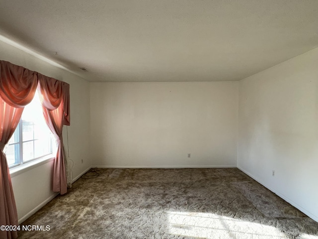 carpeted spare room featuring baseboards