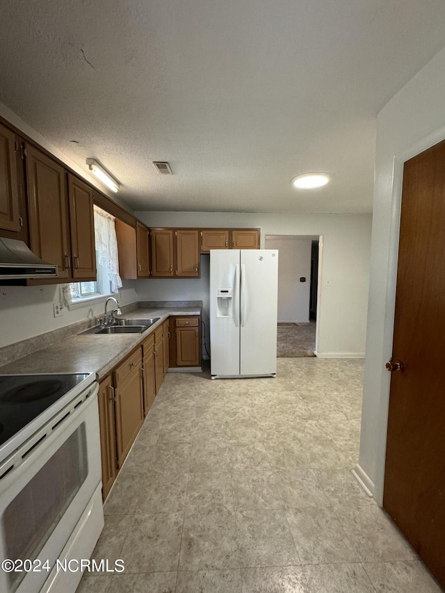 kitchen with visible vents, a sink, a textured ceiling, white appliances, and under cabinet range hood