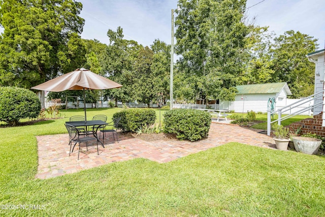 view of yard featuring a patio area and an outbuilding