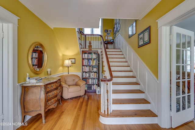 stairs with hardwood / wood-style flooring and ornamental molding