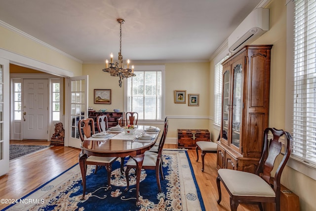 dining area with hardwood / wood-style flooring, an AC wall unit, an inviting chandelier, and ornamental molding