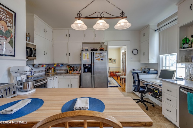 kitchen with backsplash, stainless steel appliances, white cabinetry, pendant lighting, and light tile patterned floors