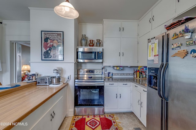 kitchen featuring appliances with stainless steel finishes, crown molding, white cabinets, and light tile patterned floors