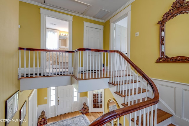 stairway with hardwood / wood-style flooring and ornamental molding