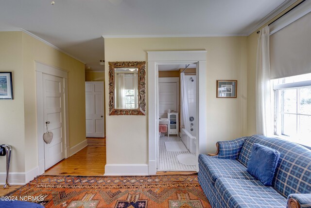 living area featuring ornamental molding and light wood-type flooring