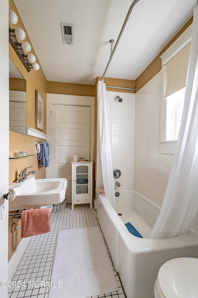 full bathroom featuring sink, shower / bath combination with curtain, toilet, and tile patterned flooring