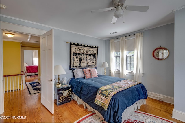 bedroom featuring ceiling fan, light hardwood / wood-style flooring, and ornamental molding