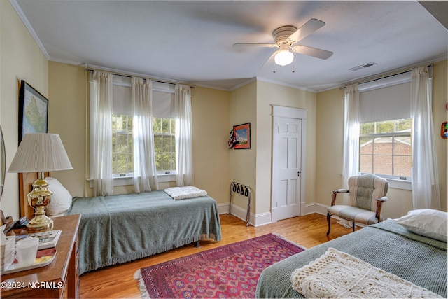 bedroom featuring ceiling fan, light hardwood / wood-style flooring, and ornamental molding