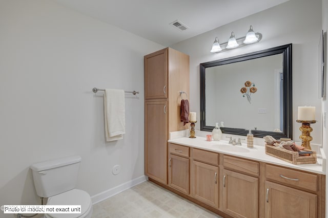 bathroom featuring vanity, toilet, and tile patterned flooring